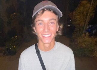 Slick Stevie smiling at night wearing gray cap and sweatshirt - popular social media influencer portrait